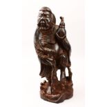 A LARGE 19TH / 20TH CENTURY CHINESE CARVED HARDWOOD FIGURE OF AN IMMORTAL, possibly carved from