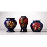 THREE VARIOUS SMALL MOORCROFT POTTERY VASES, blue ground with flowers and fruit. Two with W.