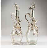 A GOOD PAIR OF GLASS CLARET JUGS AND STOPPERS, with applied plated mounts, cupids and fruiting