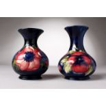 TWO MOORCROFT POTTERY VASES, blue ground with pansies and anemones. W. Moorcroft and WM initials (
