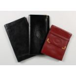 A CARTIER BLACK LEATHER WALLET and A RED WALLET, and another (3).