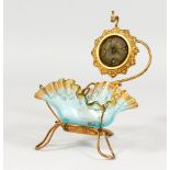 AN ORNATE GILT METAL AND GLASS WATCH HOLDER.