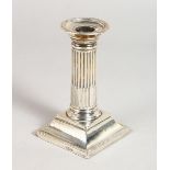 A VICTORIAN CANDLESTICK, with fluted columns, on a square base. 5ins high. Sheffield 1881. Maker:
