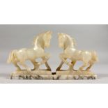 A SMALL PAIR OF CARVED ONYX HORSES, on marble bases. 4.5ins high.