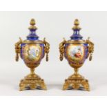 A SUPERB PAIR OF SEVRES PORCELAIN AND ORMOLU URNS AND COVERS, painted with reverse scenes of a young