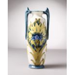A TWO-HANDLED POTTERY VASE IN THE STYLE OF MOORCROFT. (Not genuine) Mark WM 55. 8ins high.