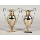 A PAIR OF SILVER TWIN-HANDLED TROPHY STYLE VASES. Birmingham 1912. 5.75ins high.