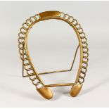 A BRASS HORSESHOE SHAPED PHOTOGRAPH FRAME. 12ins high.