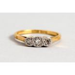 AN 18CT GOLD THREE STONE DIAMOND RING.