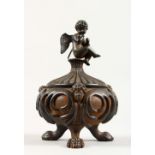 AFTER THE ANTIQUE. A CIRCULAR IRON INKWELL AND COVER, with cupid and masks, on claw feet. 4.5ins
