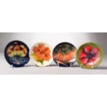 FOUR SMALL VARIOUS MOORCROFT CIRCULAR SAUCERS. 4.5ins diameter.