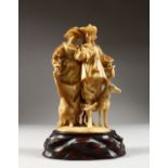 A VERY GOOD FINELY CARVED EUROPEAN IVORY GROUP OF A MAN AND WOMAN, a dog at their side. 6ins high,
