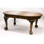 A GEORGIAN STYLE MAHOGANY EXTENDING DINING TABLE WITH TWO LEAVES, with rounded ends, on carved