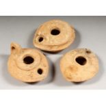 THREE ROMAN TERRACOTTA OIL LAMPS.