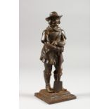 A CAST METAL FIGURE OF A MAN LEANING ON A SPADE. 7.25ins high.