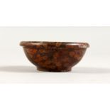 A SMALL CIRCULAR "PUDDINGSTONE" BOWL. 2.75ins diameter.