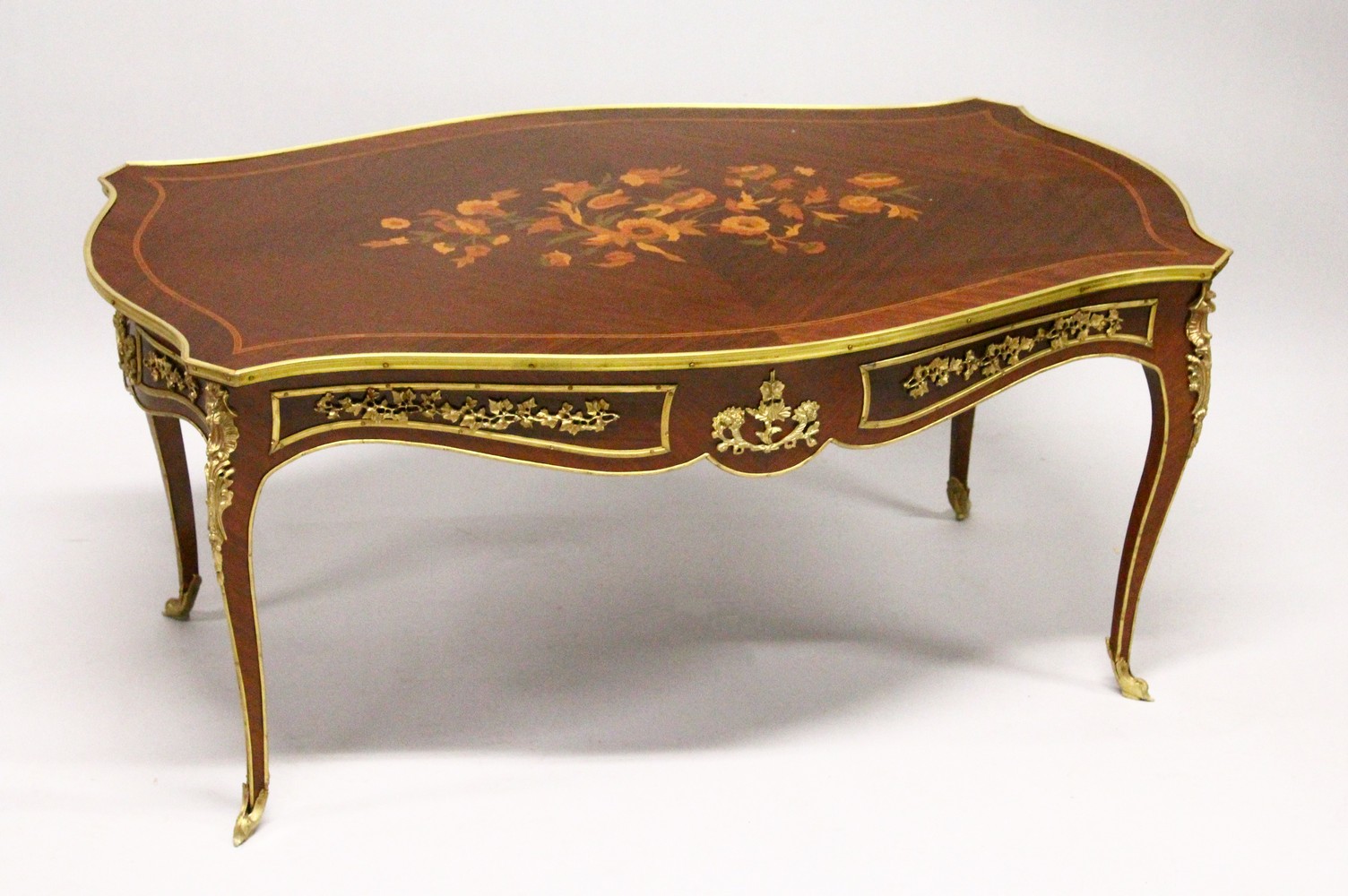 A FRENCH STYLE INLAID MAHOGANY AND ORMOLU MOUNTED COFFEE TABLE.