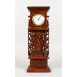 A CARVED OAK MINIATURE LONGCASE CLOCK, with watch movement. 13.5ins high.