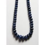 A MODERN NATURAL SAPPHIRE NECKLACE, wit facet cut graduated beads. 19ins long.