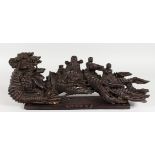 A CHINESE CARVED WOOD GROUP, many figures on a stand. 21ins long.