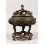 A CHINESE CIRCULAR BRONZE CENSER ON A STAND. 7ins high.