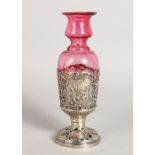 A STERLING SILVER AND RUBY GLASS VASE, repousse with Dutch scenes.