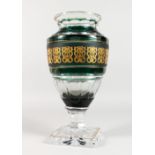 A LARGE AND HEAVY CRYSTAL VASE, with green and gilt band, faceted body, on square base, signed. 15.