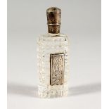 A SILVER MOUNTED CUT GLASS PERFUME BOTTLE. 3.5ins high.
