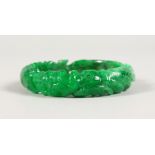 AN APPLE GREEN CARVED BANGLE.