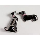 TWO SILVER AND ENAMEL DOG BROOCHES, with ruby collars.