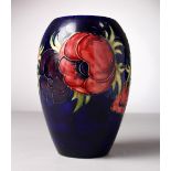 A MOORCROFT POTTERY VASE, blue ground, "Hibiscus". WM in green. 7ins high.