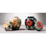 TWO SMALL MOORCROFT POTTERY GINGER JARS AND COVERS. 4.5ins high.