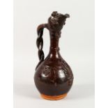 A CANAKKALE BROWN GLAZED POTTERY EWER. 15ins high.