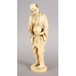 A GOOD JAPANESE MEIJI PERIOD CARVED IVORY OKIMONO - LANTERN LIGHTER, the man stod holding his