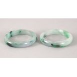 TWO 19TH / 20TH CENTURY CHINESE CARVED JADEITE BANGLES, 7.4cm diameter, internal 5.5cm.