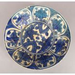 A 17TH/18TH CENTURY ISLAMIC BLUE AND WHITE POTTERY DISH with stylised floral decoration, 32.5cm