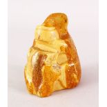 A GOOD 19TH CENTURY CHINESE CARVED NATURAL AMBER FIGURE, possibly carved in the form of a brush