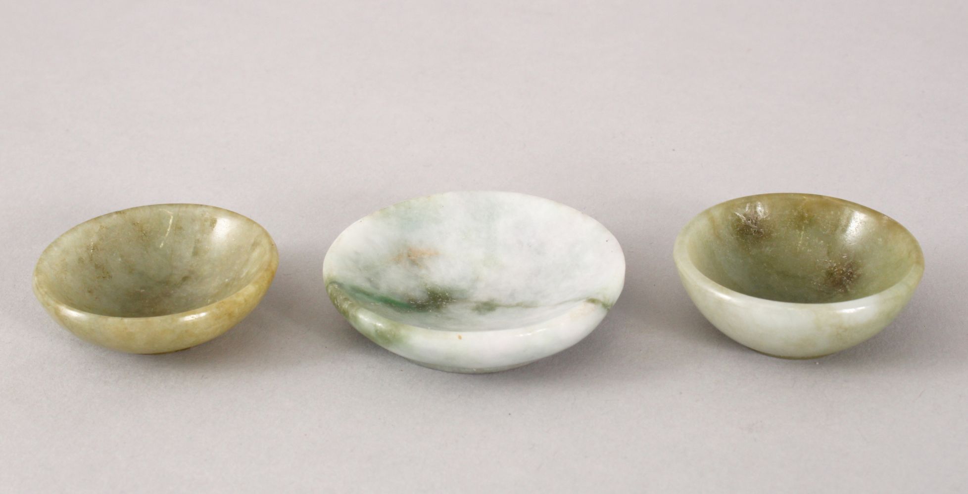 THREE 19TH / 20TH CENTURY CHINESE CARVED JADE / JADEITE BOWLS, 5cm & 4cm.