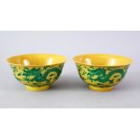 A GOOD PAIR OF CHINESE YELLOW GROUND DRAGON BOWLS, the side of the bows decorated with scenes of