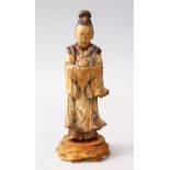 A GOOD 18TH CENTURY CHINESE CARVED & PAINTED SOAPSTONE FIGURE, possibly of guanyin, holding a fruit,