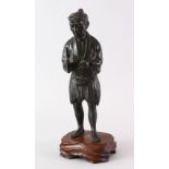 A GOOD JAPANESE MEIJI PERIOD BRONZE OKIMONO - OPIUM SMOKER, the mas stood upon a hardwood carved