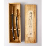 A GOOD BOXED PAIR OF JAPANESE MEIJI PERIOD MINIATURE SWORDS, 21CM & 17CM, in original signed