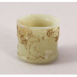 A 19TH / 20TH CENTURY CHINESE CARVED CELADON JADE ARCHERS RING, carved with birds among blossom