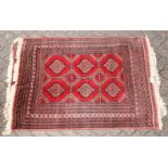 A 20TH CENTURY BOKHARA STYLE RUG, red ground with six central medallions. 5ft 4ins x 4ft 0ins.