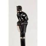 A VERY GOOD EBONY CANE, EARLY 20TH CENTURY, the handle well carved as a pug dog seated on a cushion,