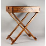 A NOVELTY HARDWOOD TRAY ON FOLDING STAND. Tray: 25.5ins long.