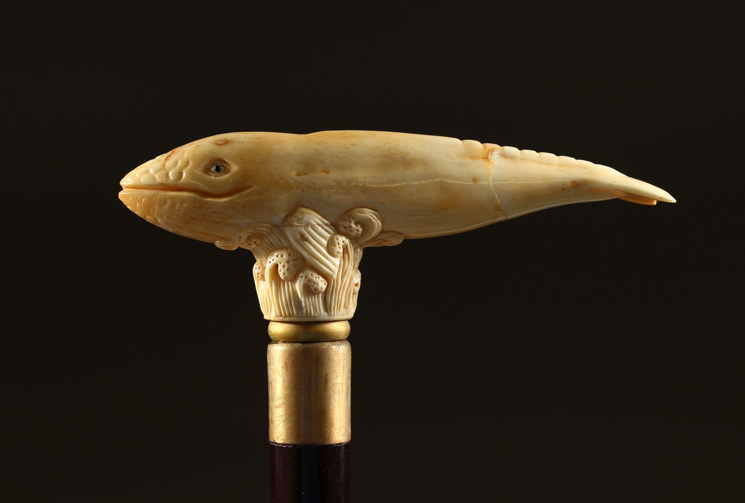 A BONE HANDLE WALKING STICK, carved as a whale. 36ins long.