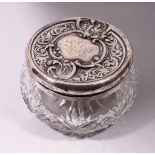 A STERLING SILVER CIRCULAR CUT GLASS POWDER BOWL, with repousse silver top. 4.5ins diameter.