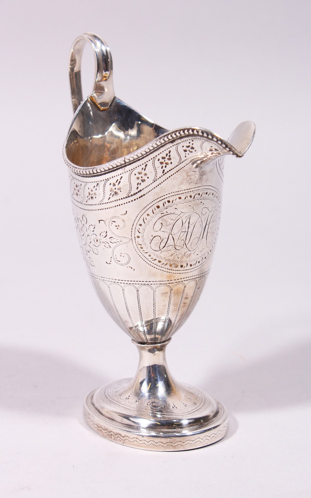 A GOOD GEORGE III ENGRAVED HELMET SHAPED MILK JUG, with reeded handle and base. London 1782.