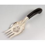 AN EASTERN WHITE METAL FORK, with engraved decoration. 8ins long.